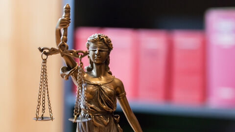 Justitia vor einem Bücherregal